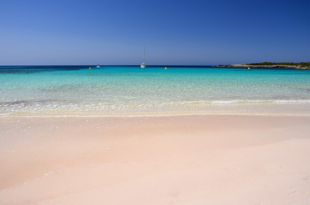 Idylická písečná pláž Son Saura na Menorce, které se přezdívá "Karibik Středomoří".