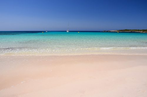 Idylická písečná pláž Son Saura na Menorce, které se přezdívá 